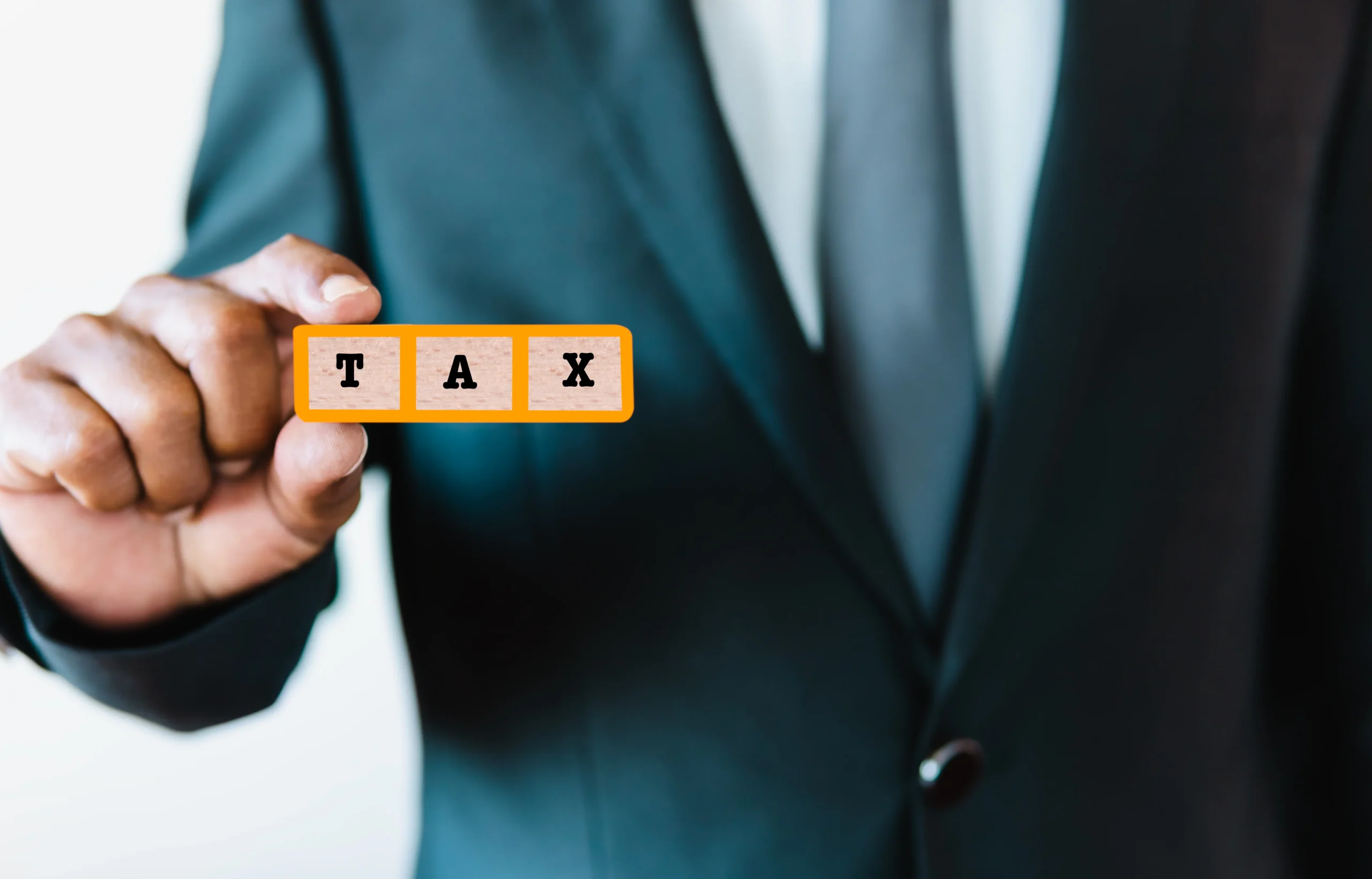 Impetus Group | What Does a Tax Agent in Singapore Do, and When Should a Business Engage One? Tax professional holding blocks spelling tax, representing services from a tax agent in Singapore.