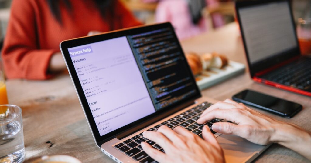 Typing code on a laptop, skills firms outsource IT for.